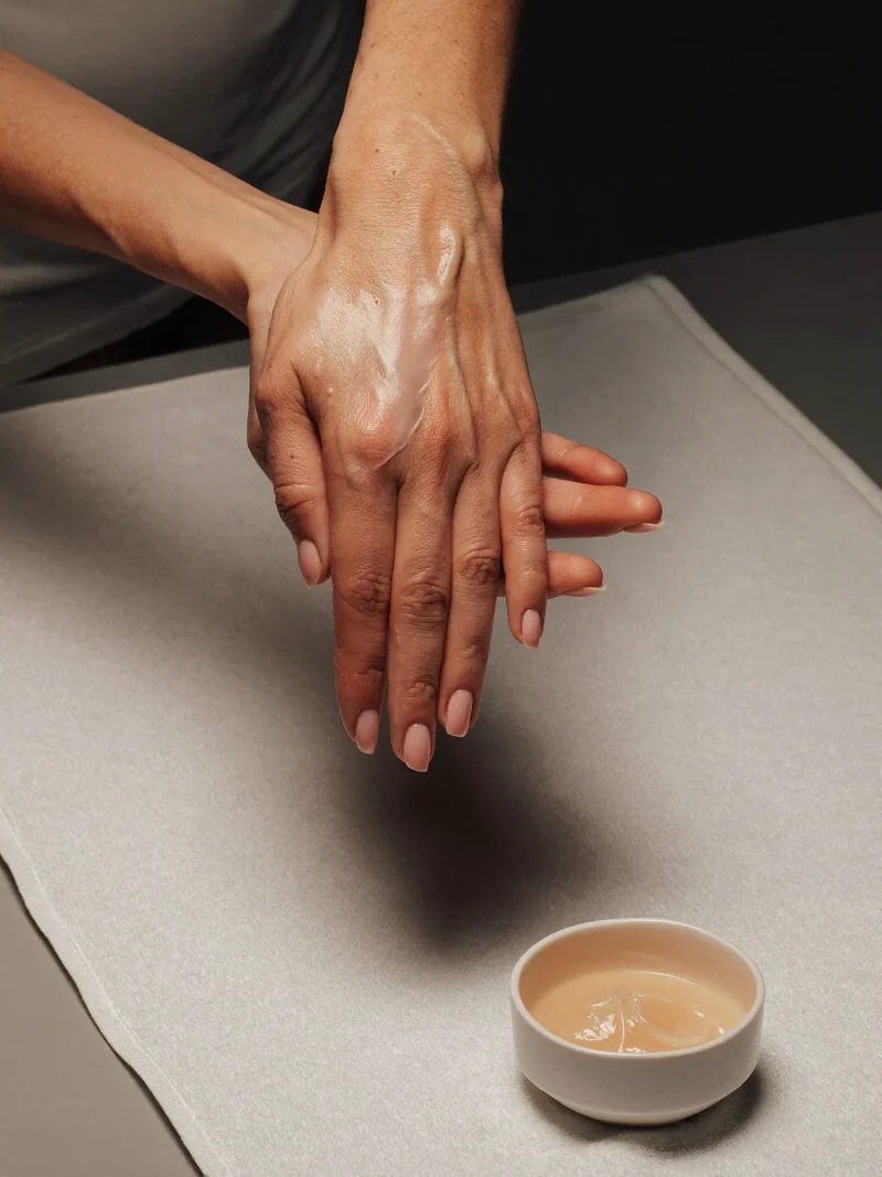 Illustration einer sanften Handmassage mit warmer Pflege und einer Schale Wachs